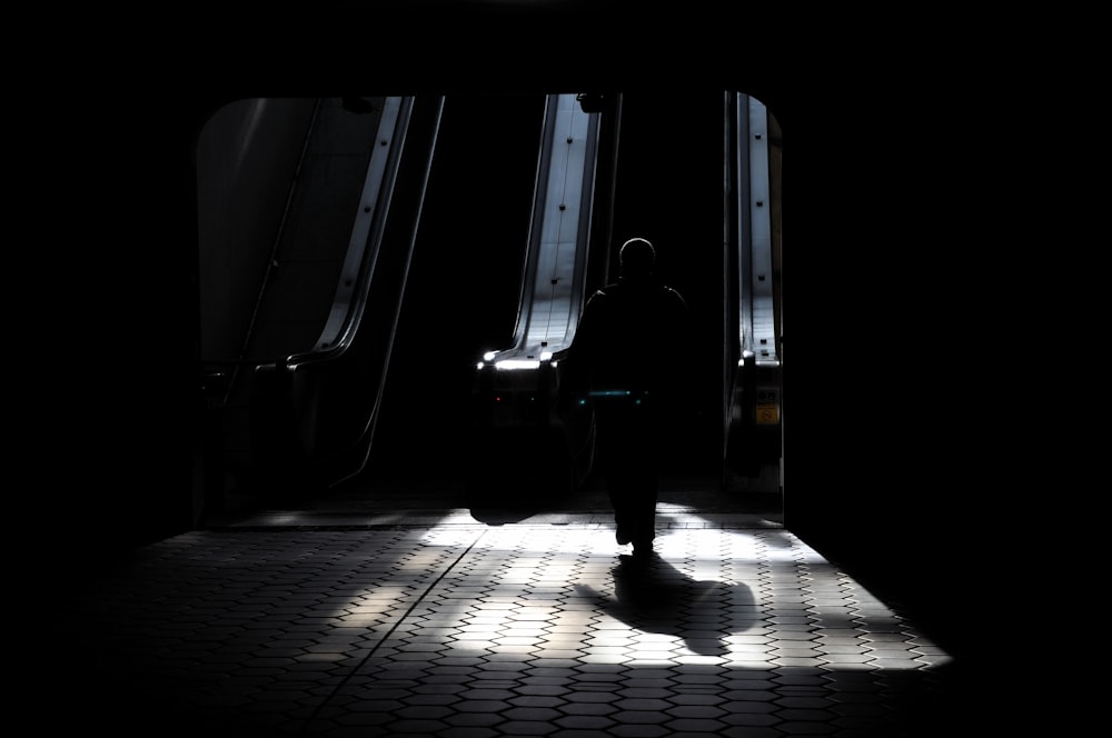 a person standing in the dark with their luggage