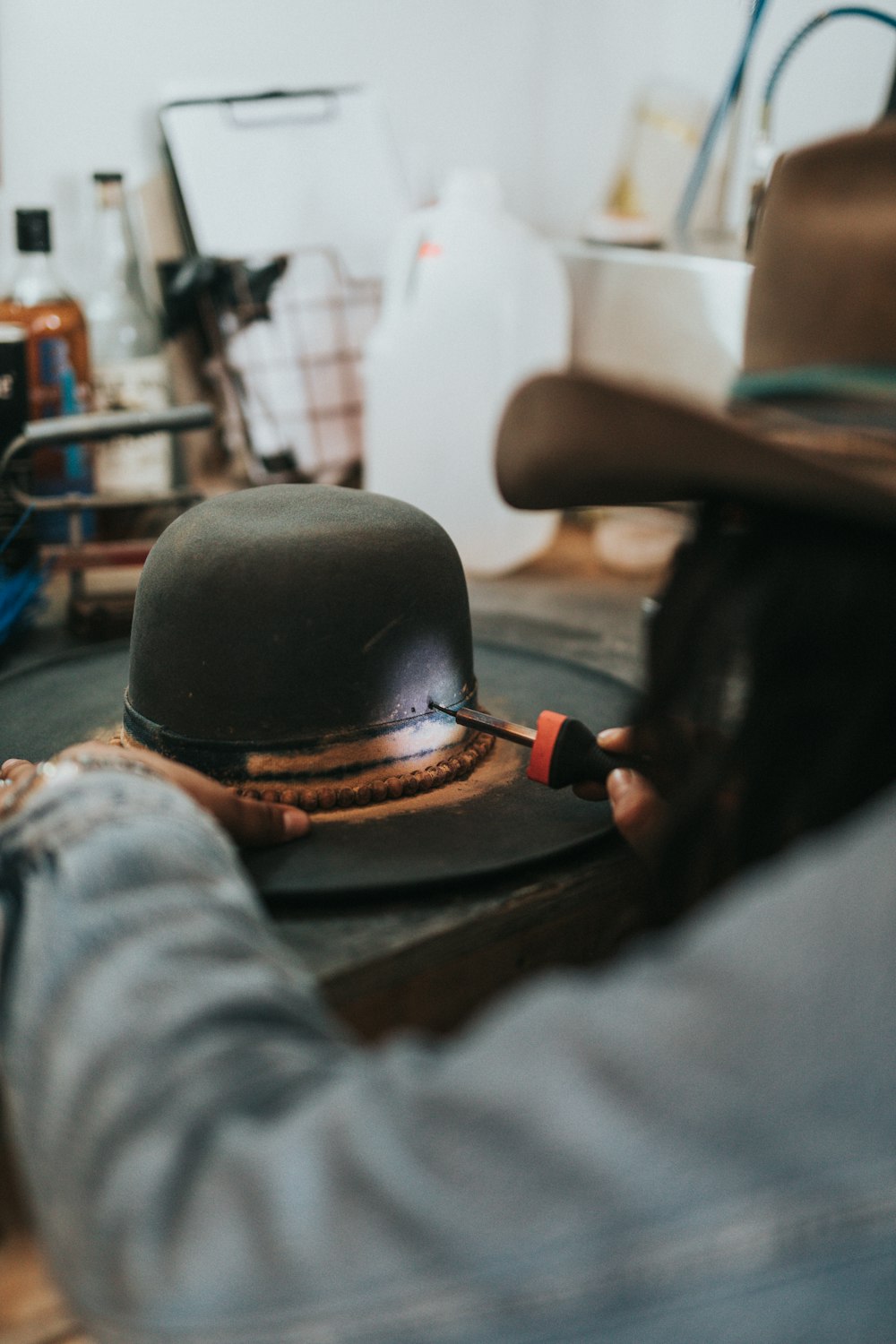 man fixing black and brown hat
