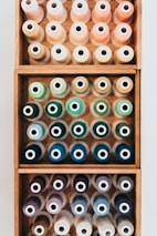 Colorful threads and finished textile samples neatly arranged on a wooden table.