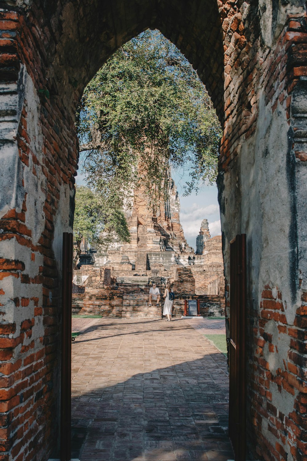 two people standing inside temple ruins