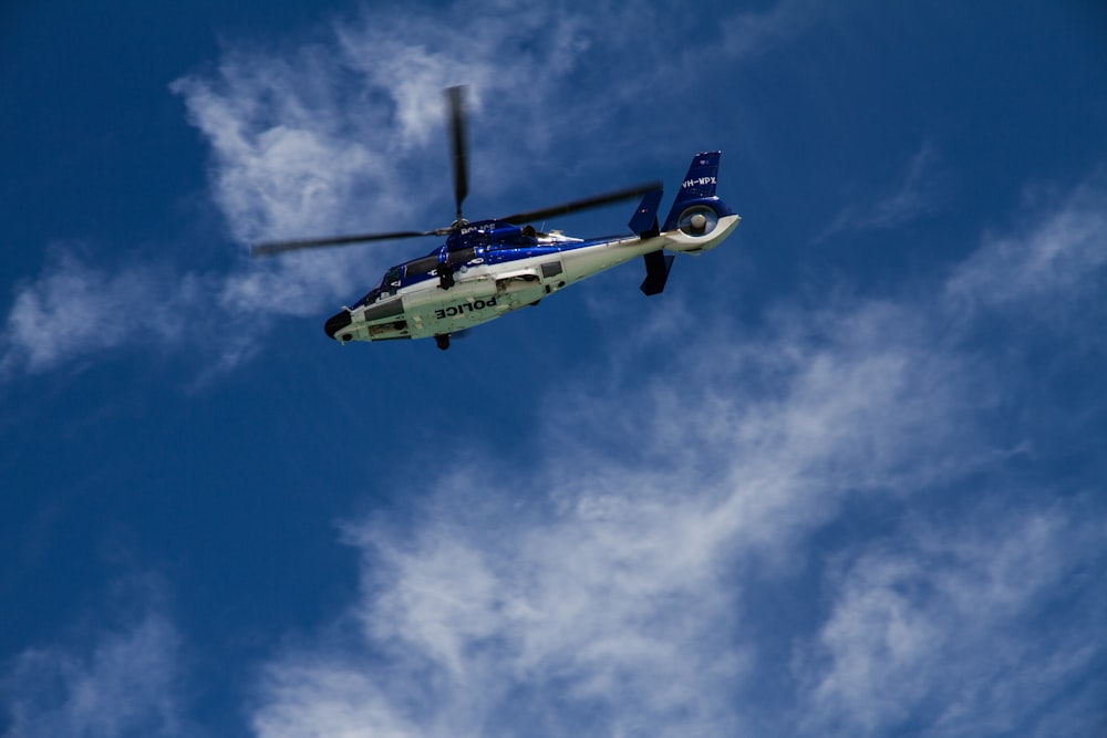 low-angle photography of white and blue helicopter