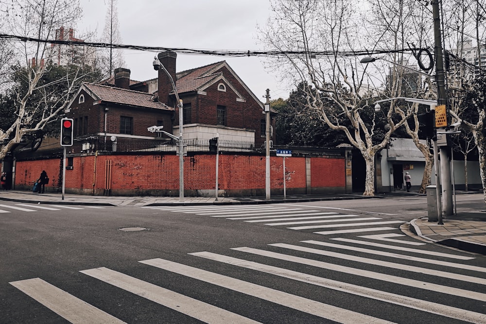 Casa de madera marrón y roja junto al pavimento de hormigón durante el día