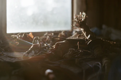 Close-up of tangled wires and oily surfaces glistening under dim, static-filled light.