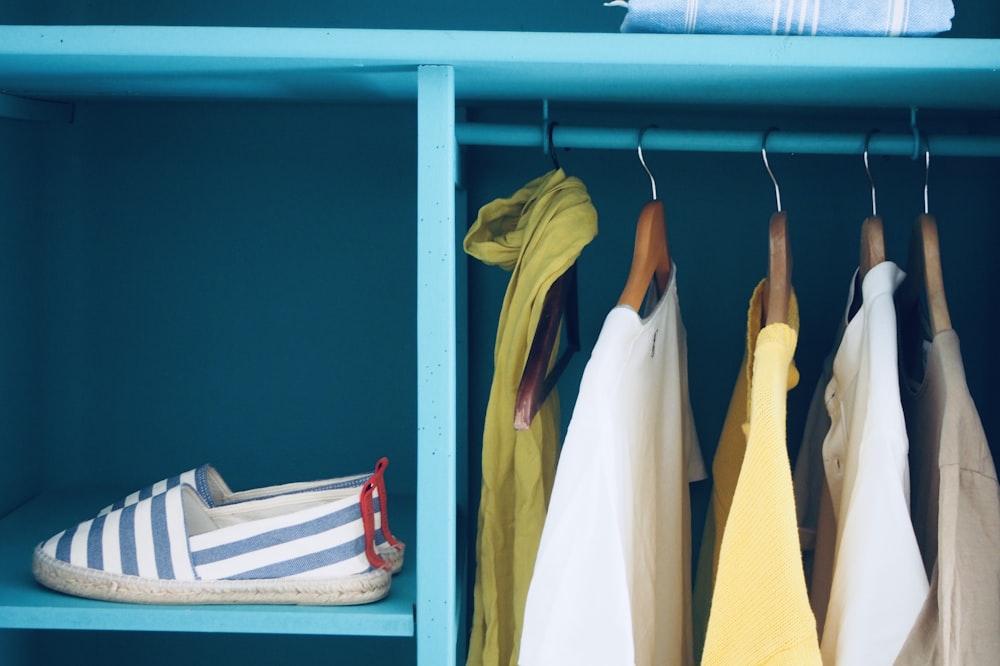 blue shelf with pair of slip-ons and five clothes