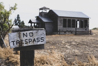 no trespass sign on post near wooden building