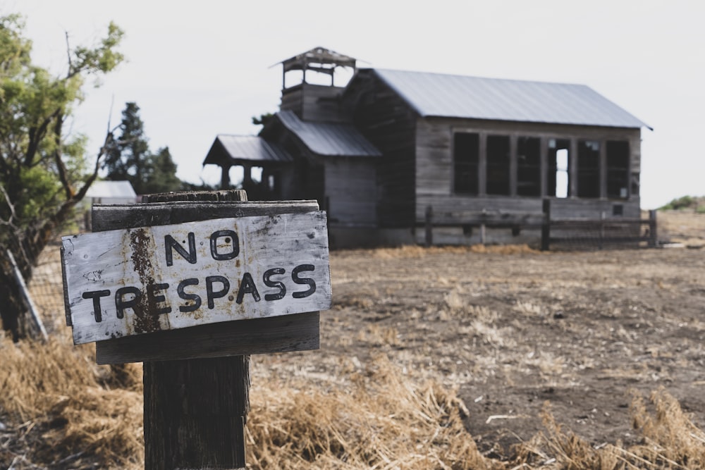 no trespass sign on post near wooden building