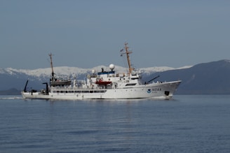 whtie boat sailing on calm sea during daytime