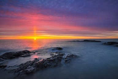 landscape photography,how to photograph sunrise over lake superior near black rocks; aerial photography of snow covered mountain during golden hour