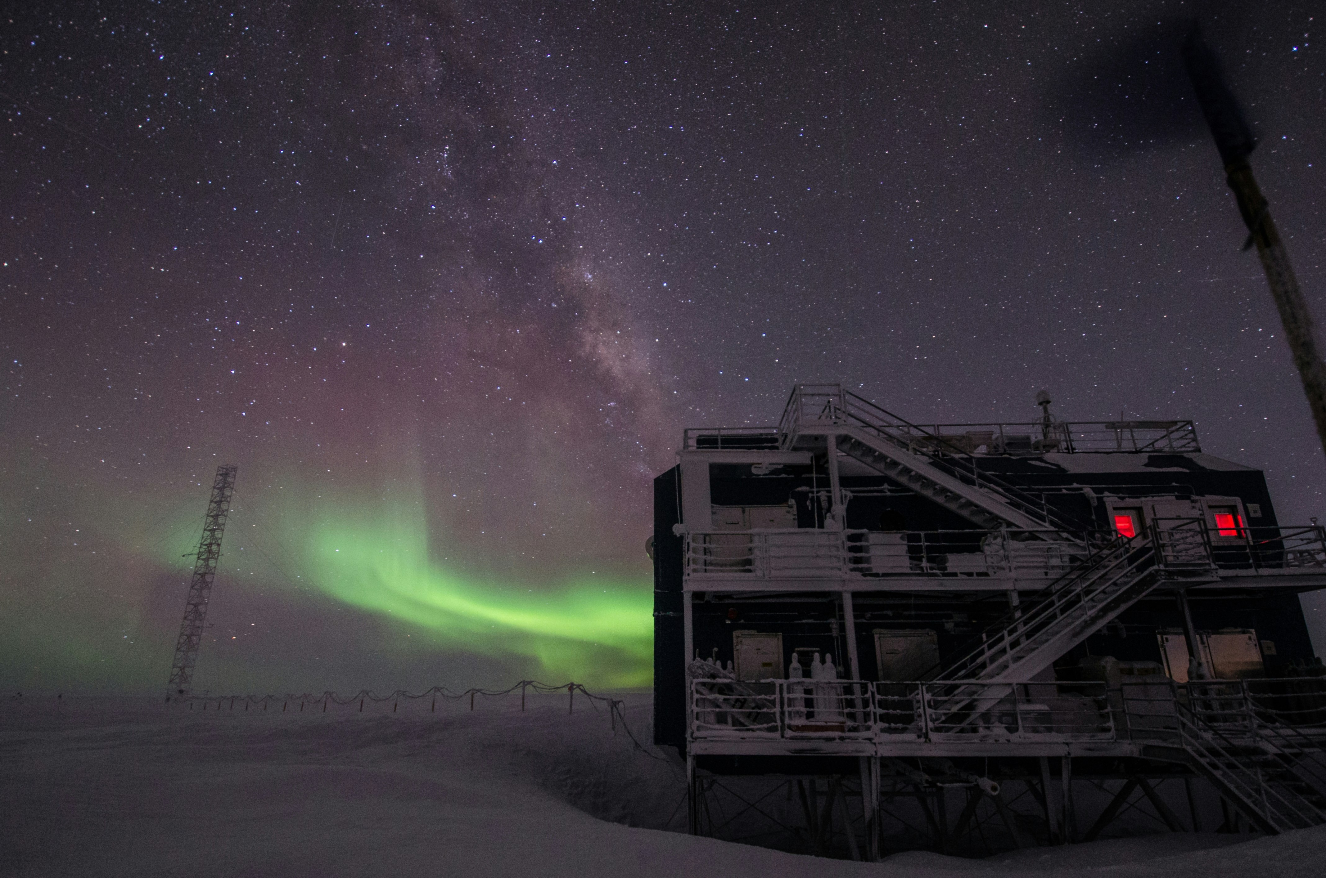 white multi-storey building under starry night and northern lights