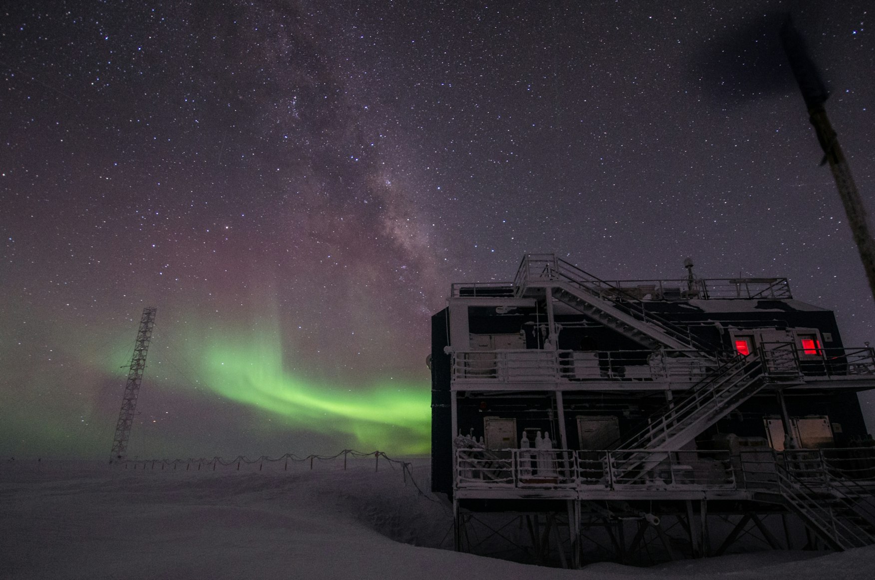 building in snow with northern lights in the background