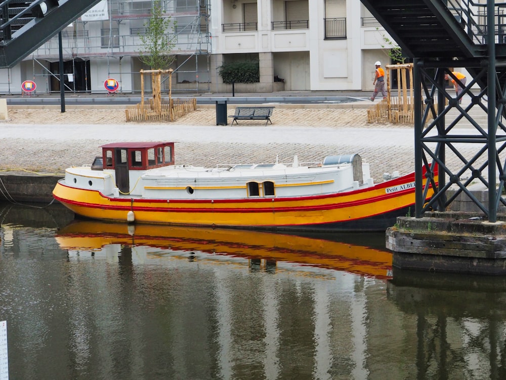 barco branco e laranja no corpo da água