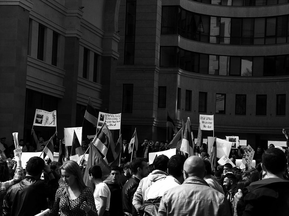 grayscale photography of people outside the building