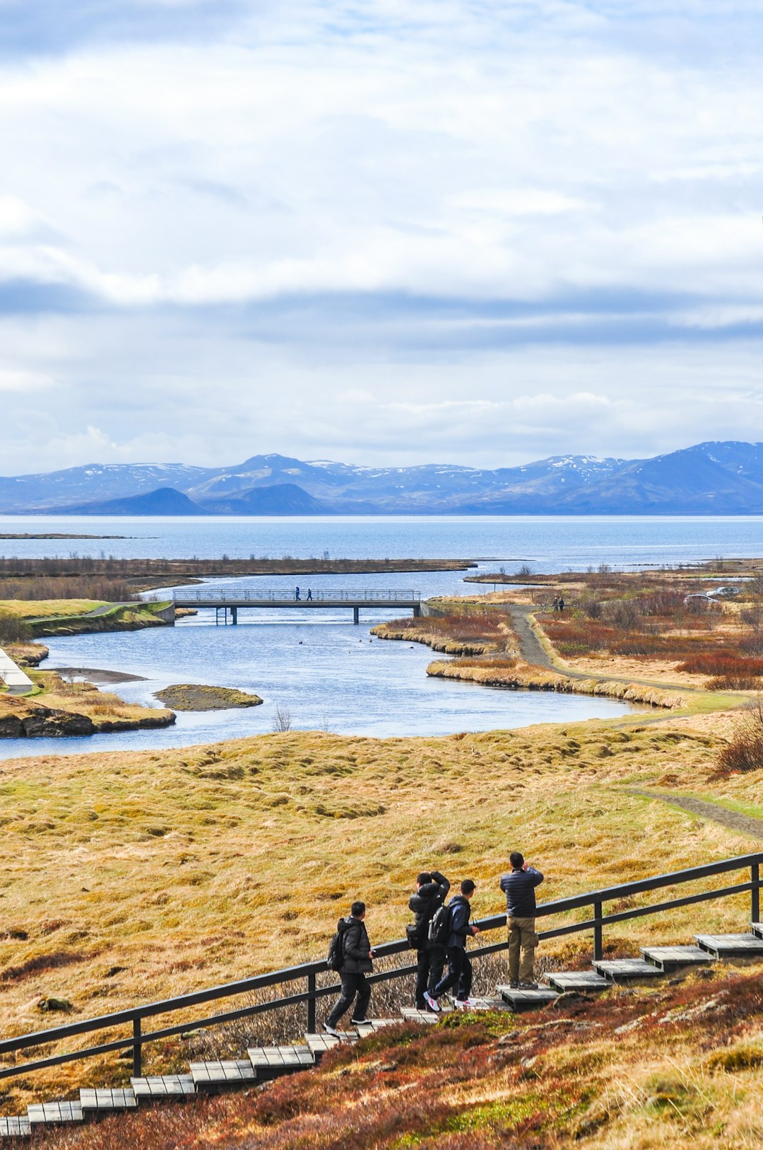 people waking on walkway near mountain during daytime