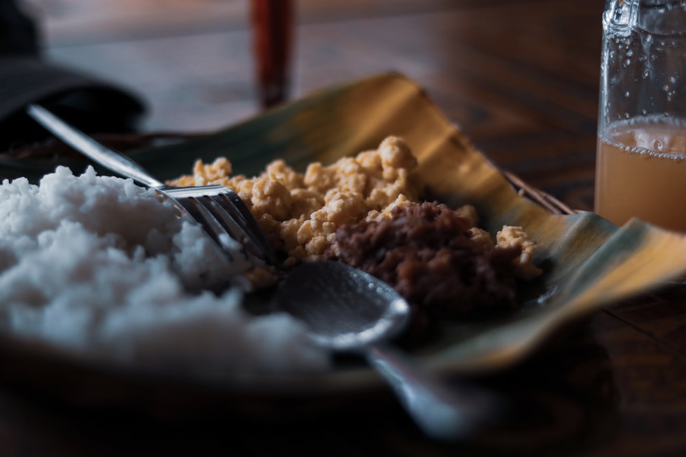 cooked food beside fork and spoon on plate close-up photography