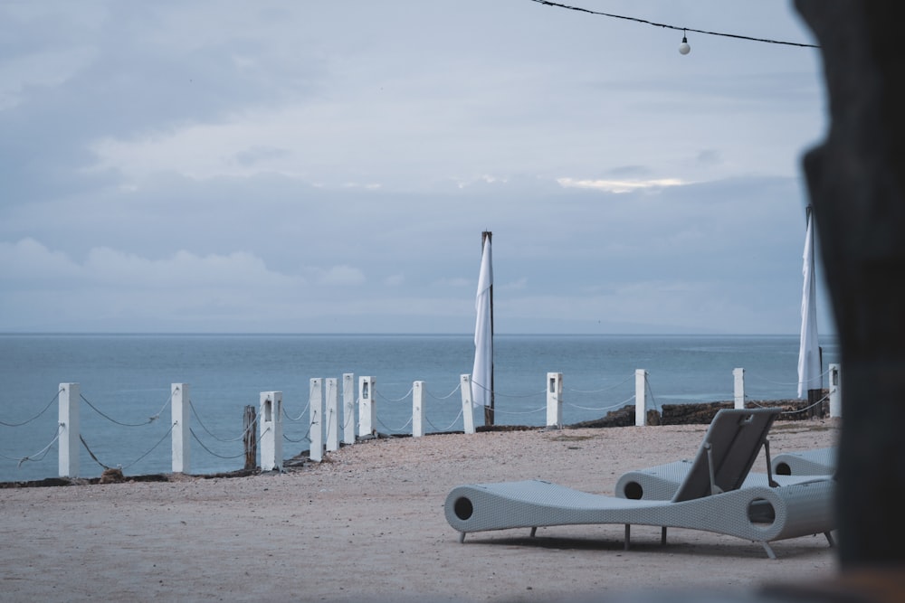 white lounge chair near body of water at daytime