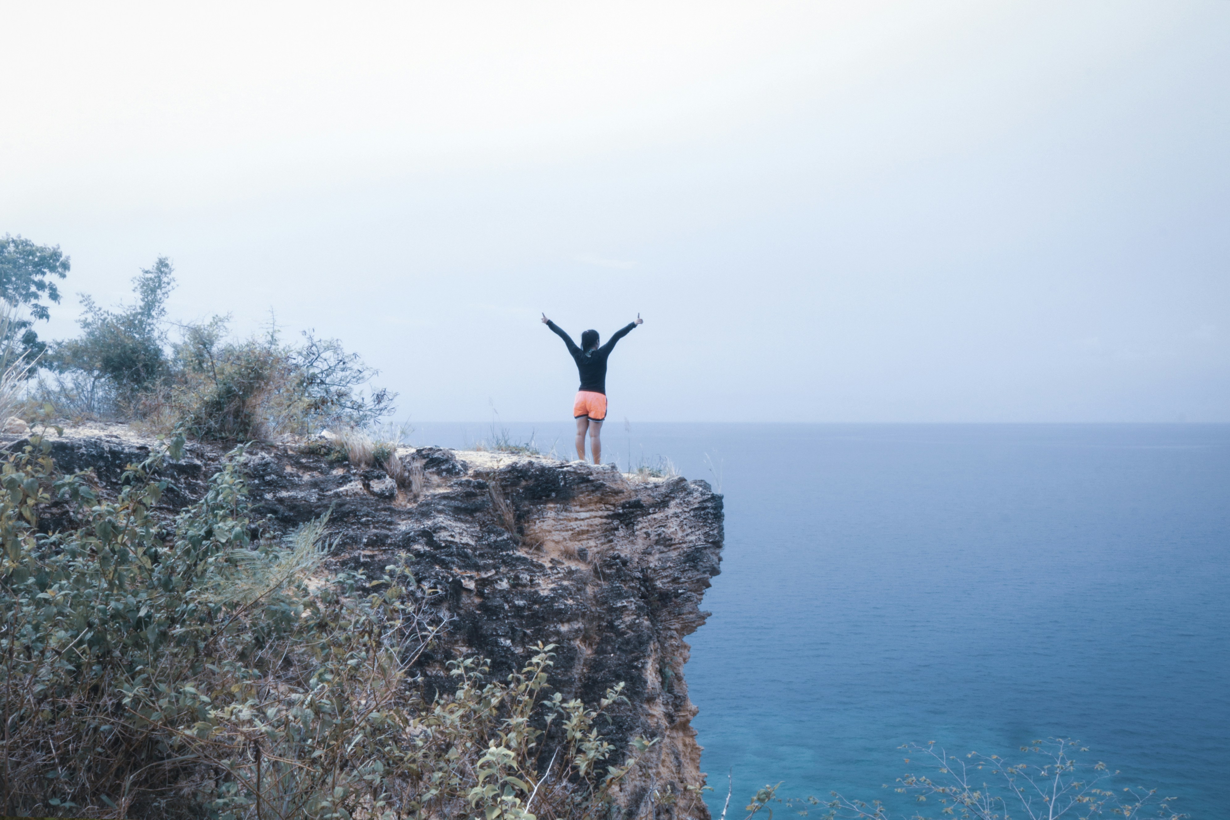 man in black and orange on a cliff, Cliff