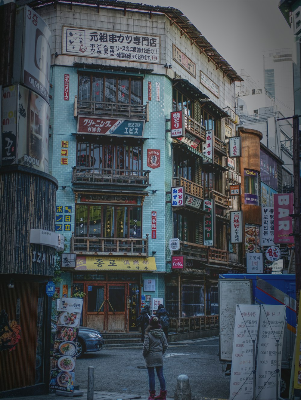 person standing beside high building close-up photography