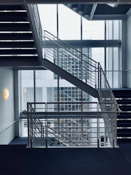architectural photography of white stair handrail