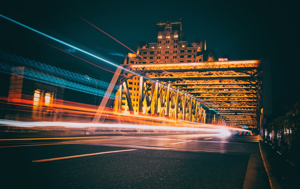 Photographie en accéléré d’un véhicule en mouvement sur le pont la nuit