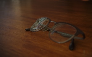 Close-up shot of trendy eyeglasses with sleek black frames on a wooden table.