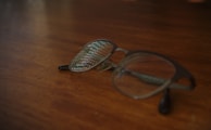 A close-up of prescription glasses on a wooden table.
