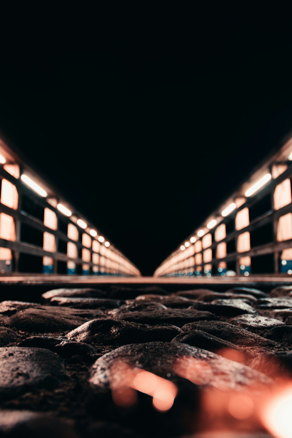 a black and white photo of a walkway at night