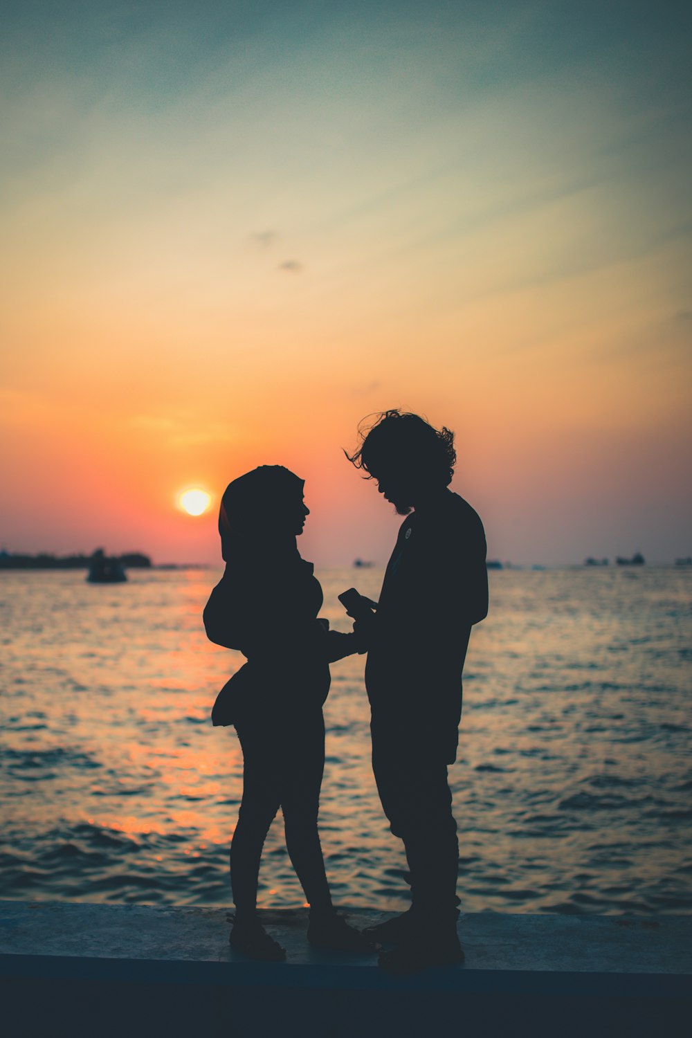 silhouette of couple on shore