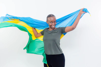 Close-up of a smiling person holding a Brazilian flag-themed product in a bright setting.
