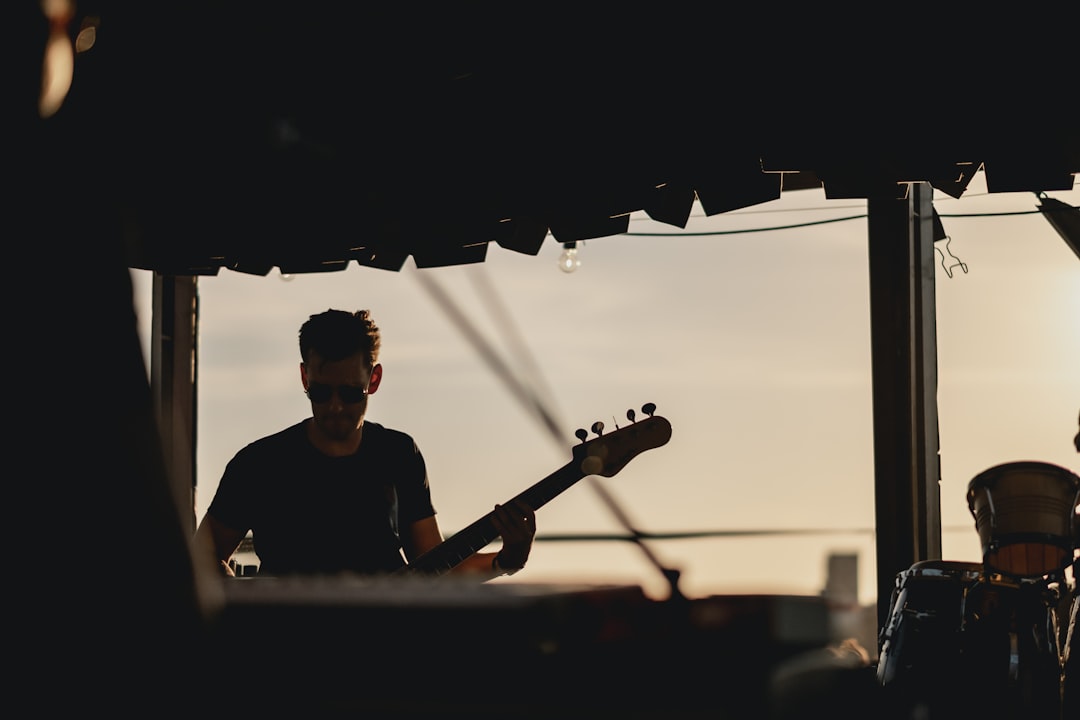 photo of man playing bass guitar