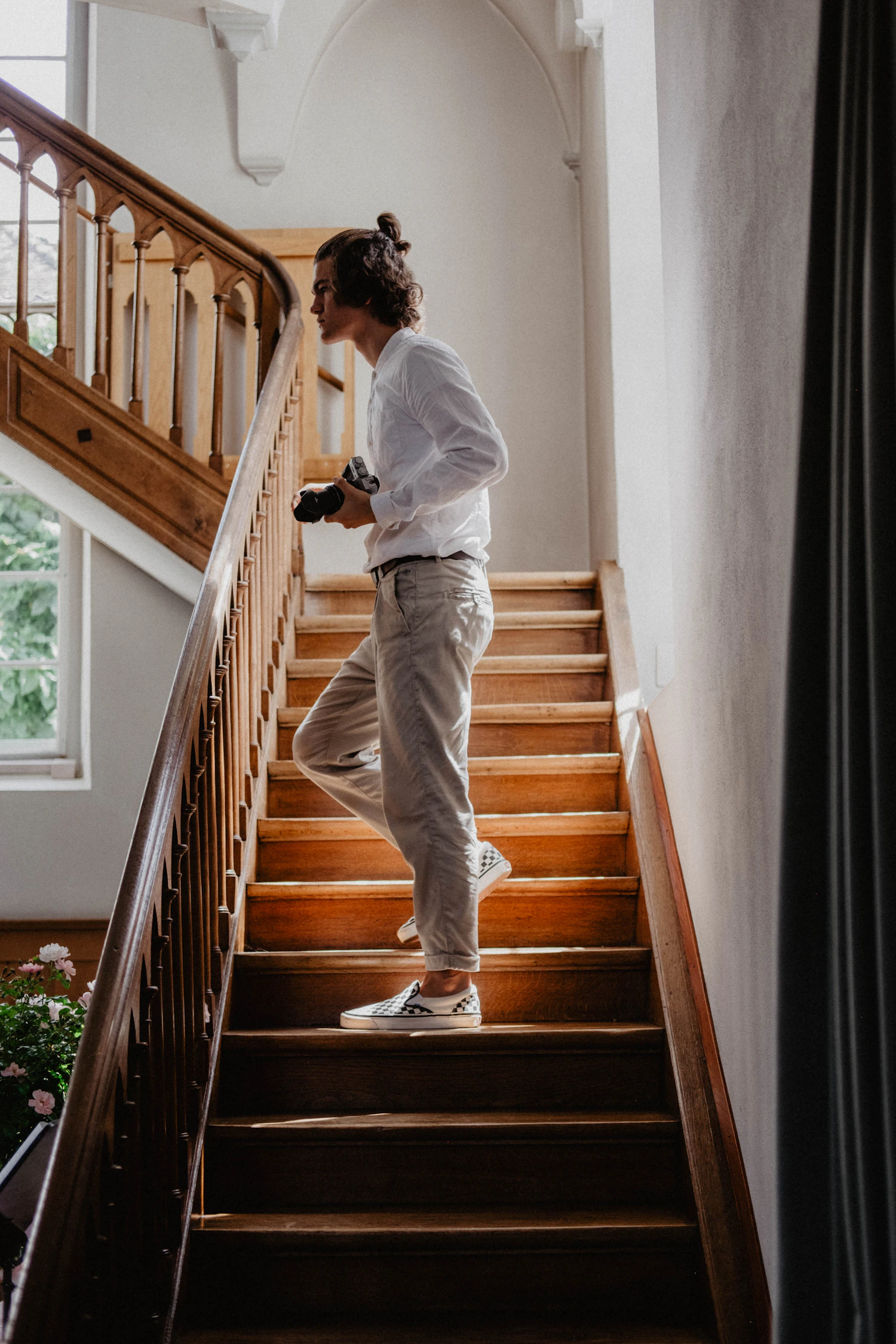 Adult walking up a wooden staircase in a light-filled home