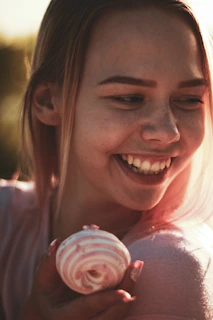 A joyful customer holding a box of freshly baked vegan donuts with a big smile