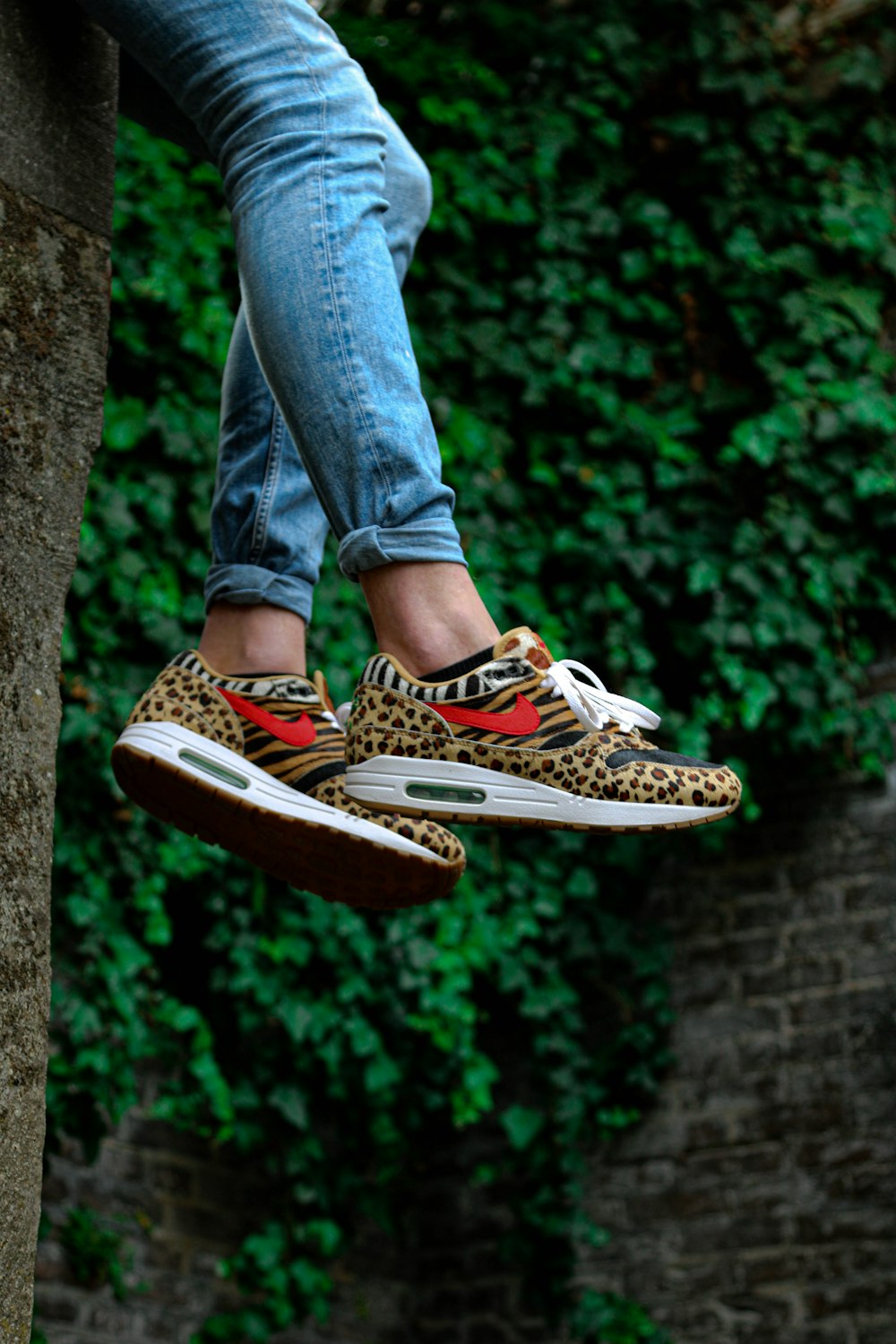 persona che indossa scarpe da ginnastica leopardate