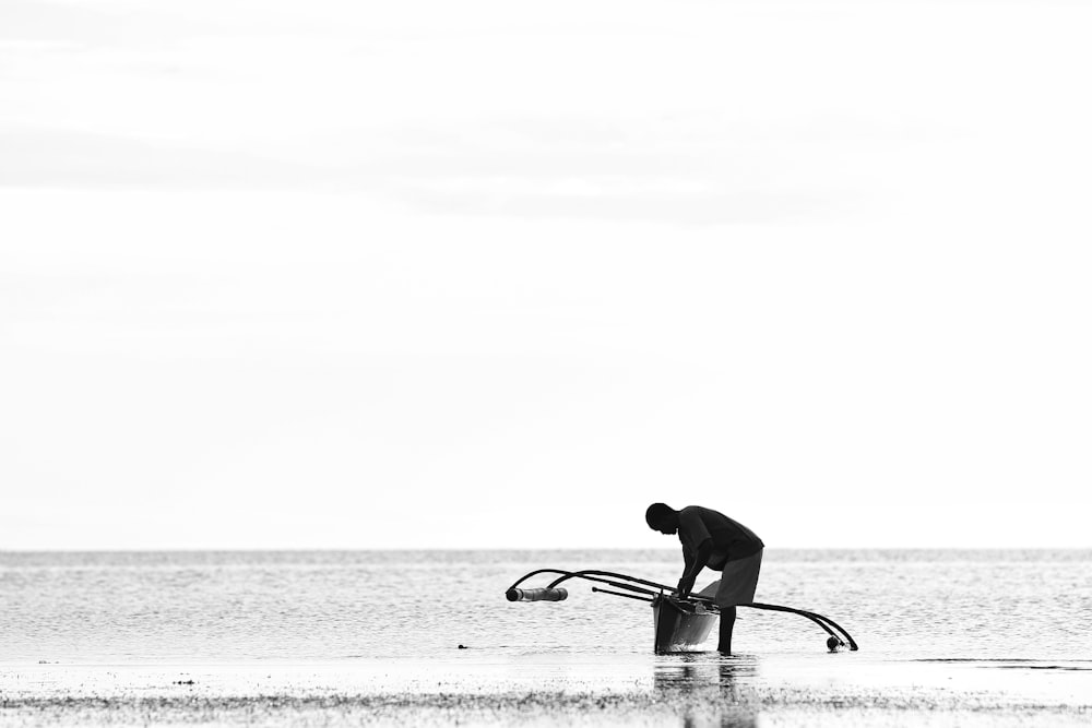 silhouette of man standing beside boat