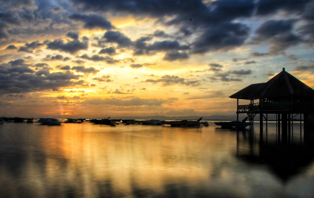 silhouette of wooden cottage in beach at sunset