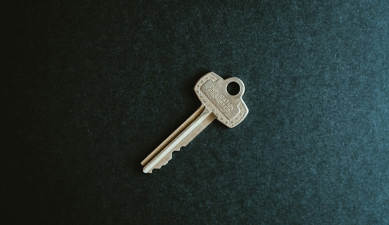 Close up of house keys and a home purchase contract on a table during a real estate closing