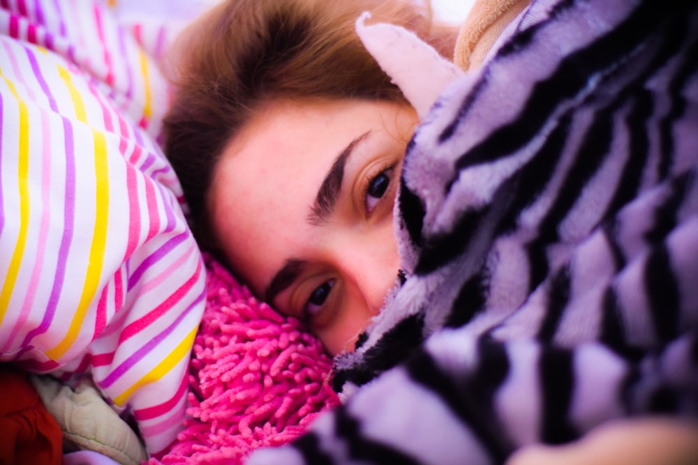 selective focus photography of woman lying on textile