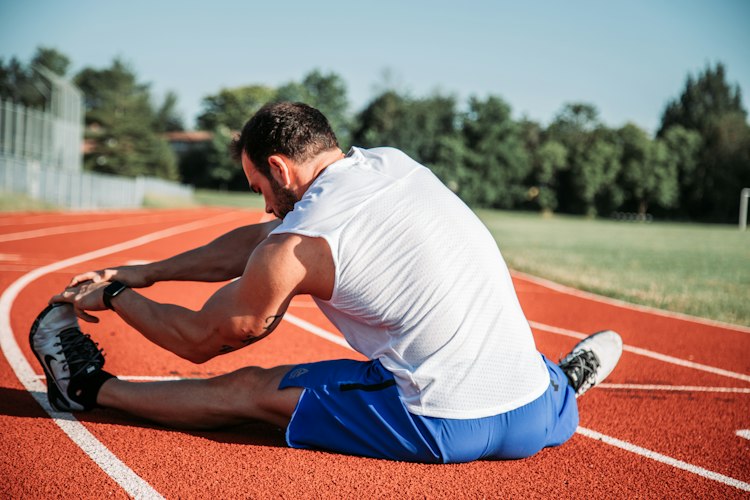 Person foam rolling their leg muscles on a mat at home