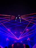 a group of people standing around a stage with lights on it