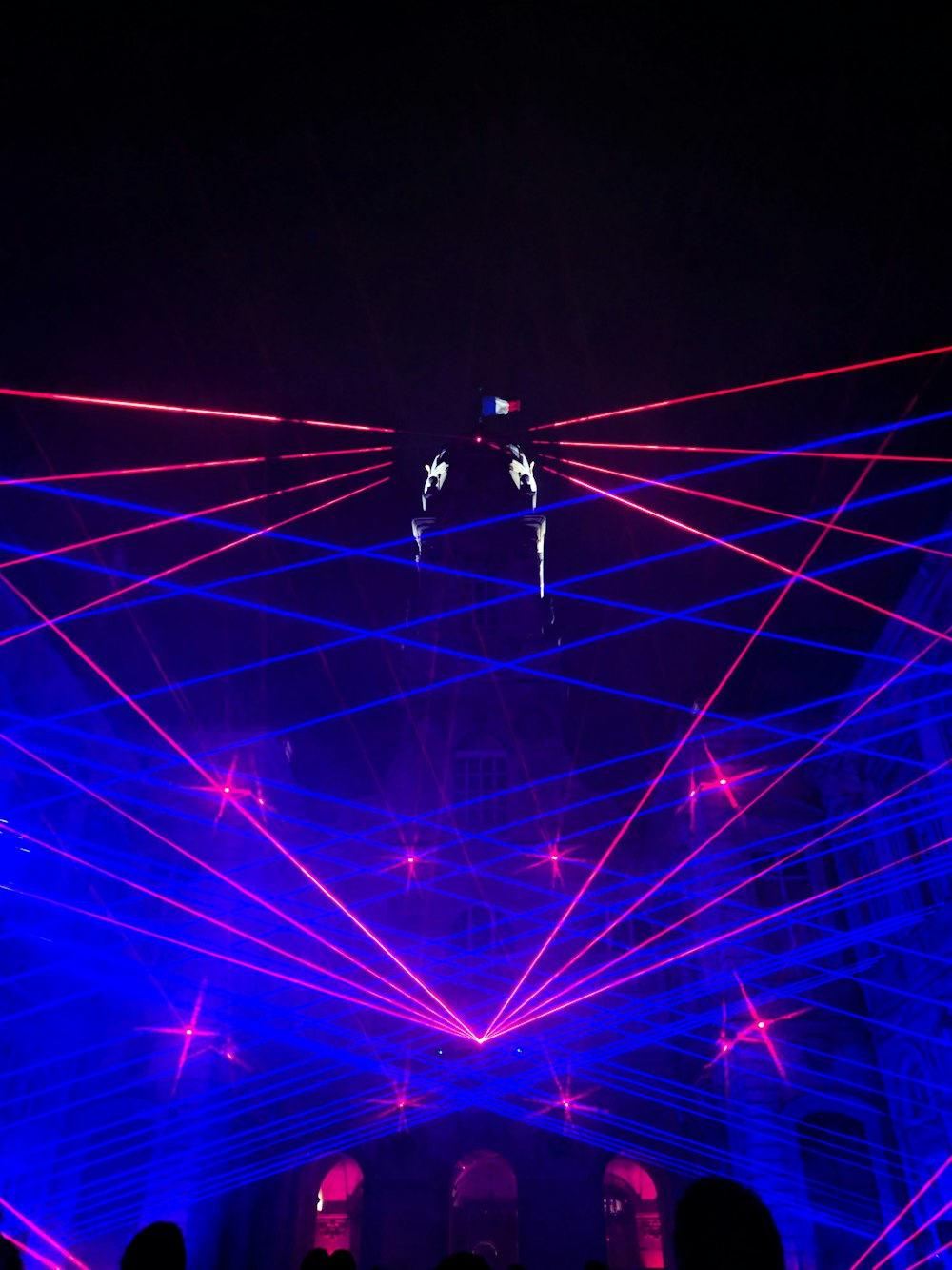 a group of people standing around a stage with lights on it