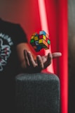 Close-up of hands expertly twisting a bright Rubik's cube against a cozy background.