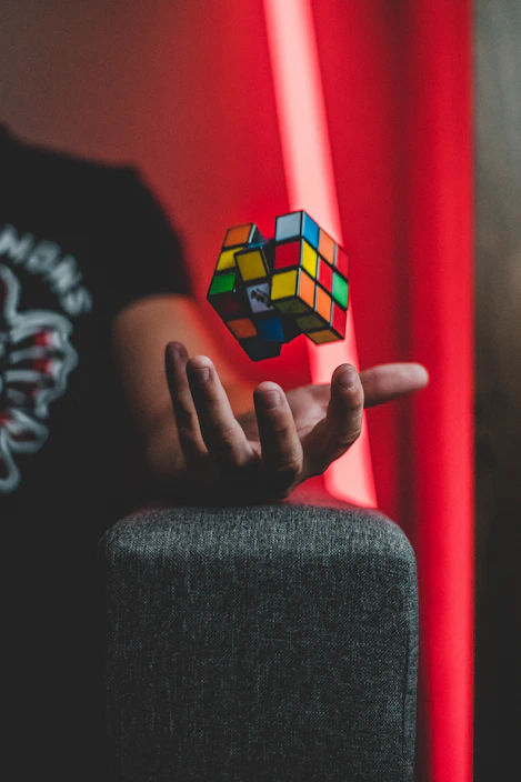 A dynamic shot of hands twisting a colorful speed cube mid-solve against a clean background.