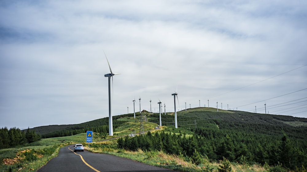 Fahrzeug fährt an Windrädern vorbei