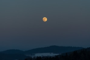 Full moon glowing over a quiet landscape on December 4th