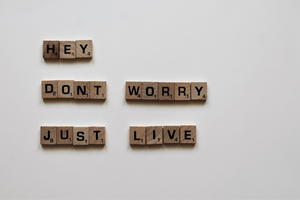 brown wooden game tiles saying hey don't worry just live