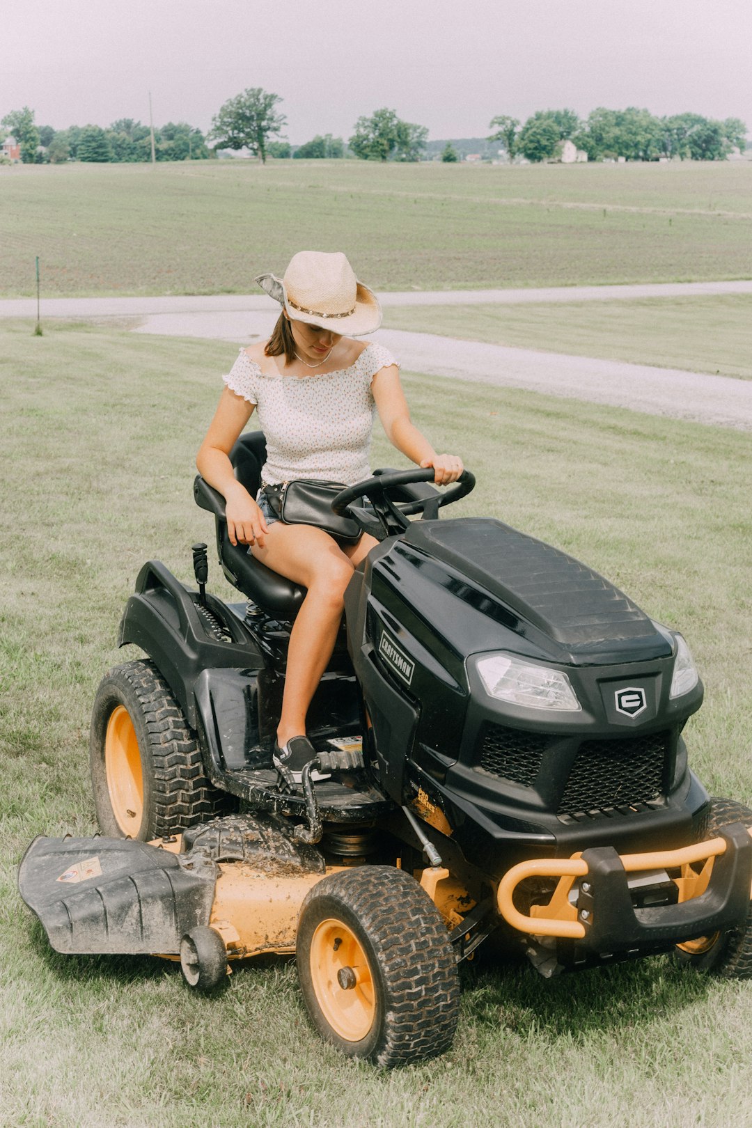 woman riding black riding mower