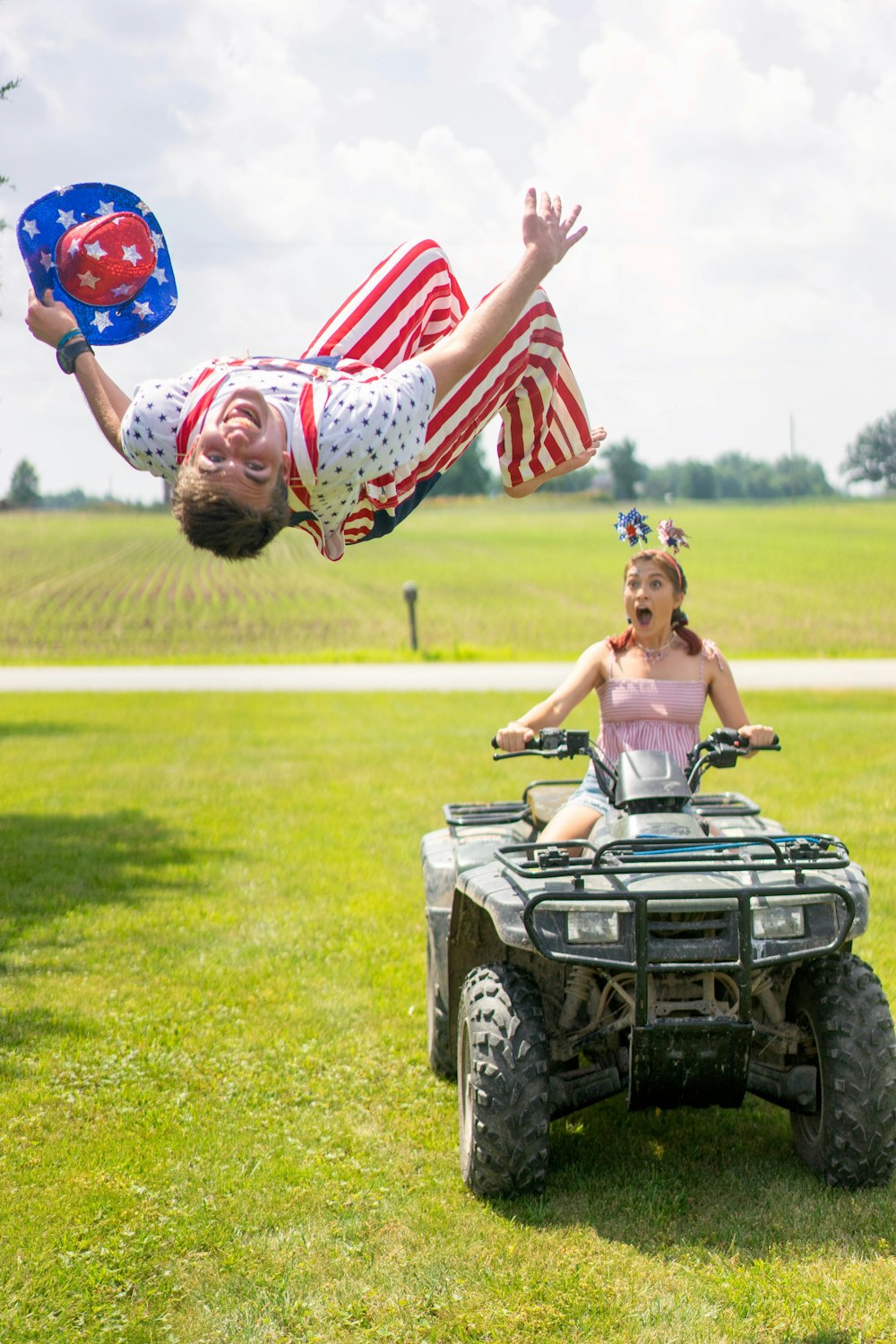 woman riding on ATV near man flying at the ground