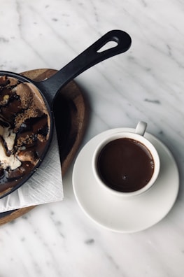 An overhead shot of a rich coffee dessert plate paired with a dark roast cup.