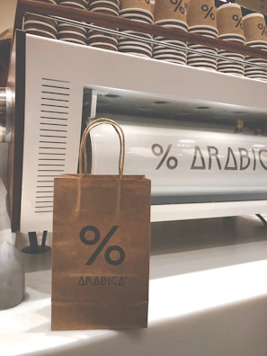 Packets of custom-branded coffee bags stacked carefully on a factory shelf, highlighting precise craftsmanship.