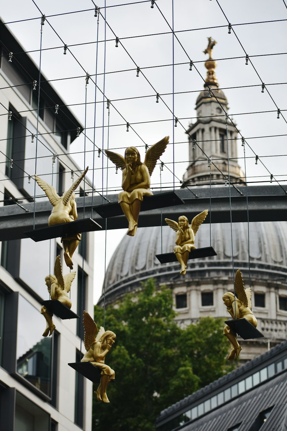 six gold-colored angels hanged on hallow ceiling