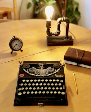 A cozy editorial workspace with books, manuscripts, and a vintage typewriter bathed in warm light.